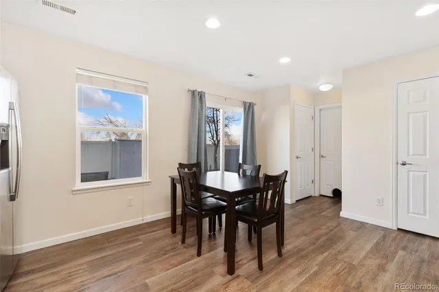 a view of a a dining room with furniture window and wooden floor