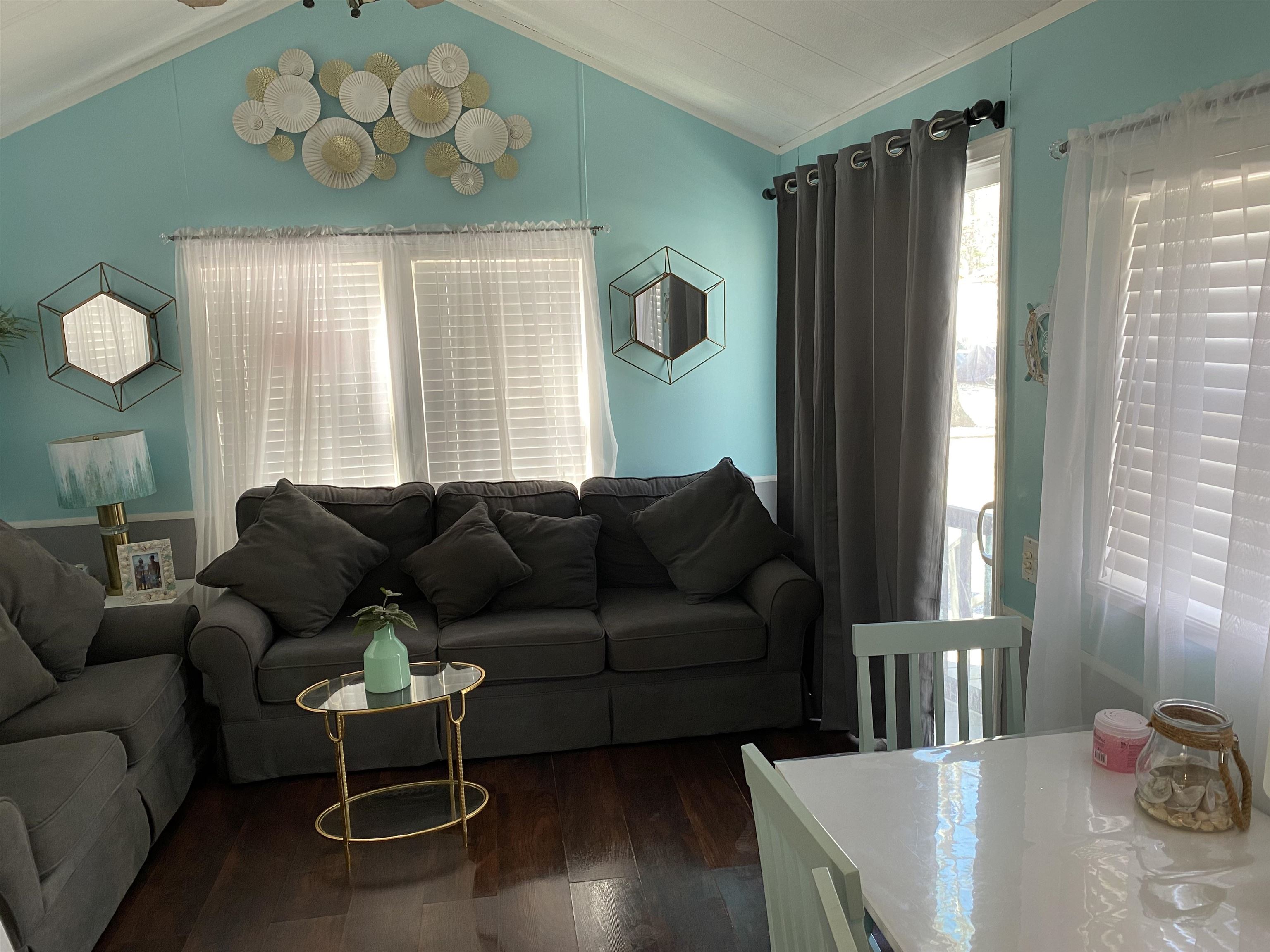 a living room with furniture wooden floor and a chandelier