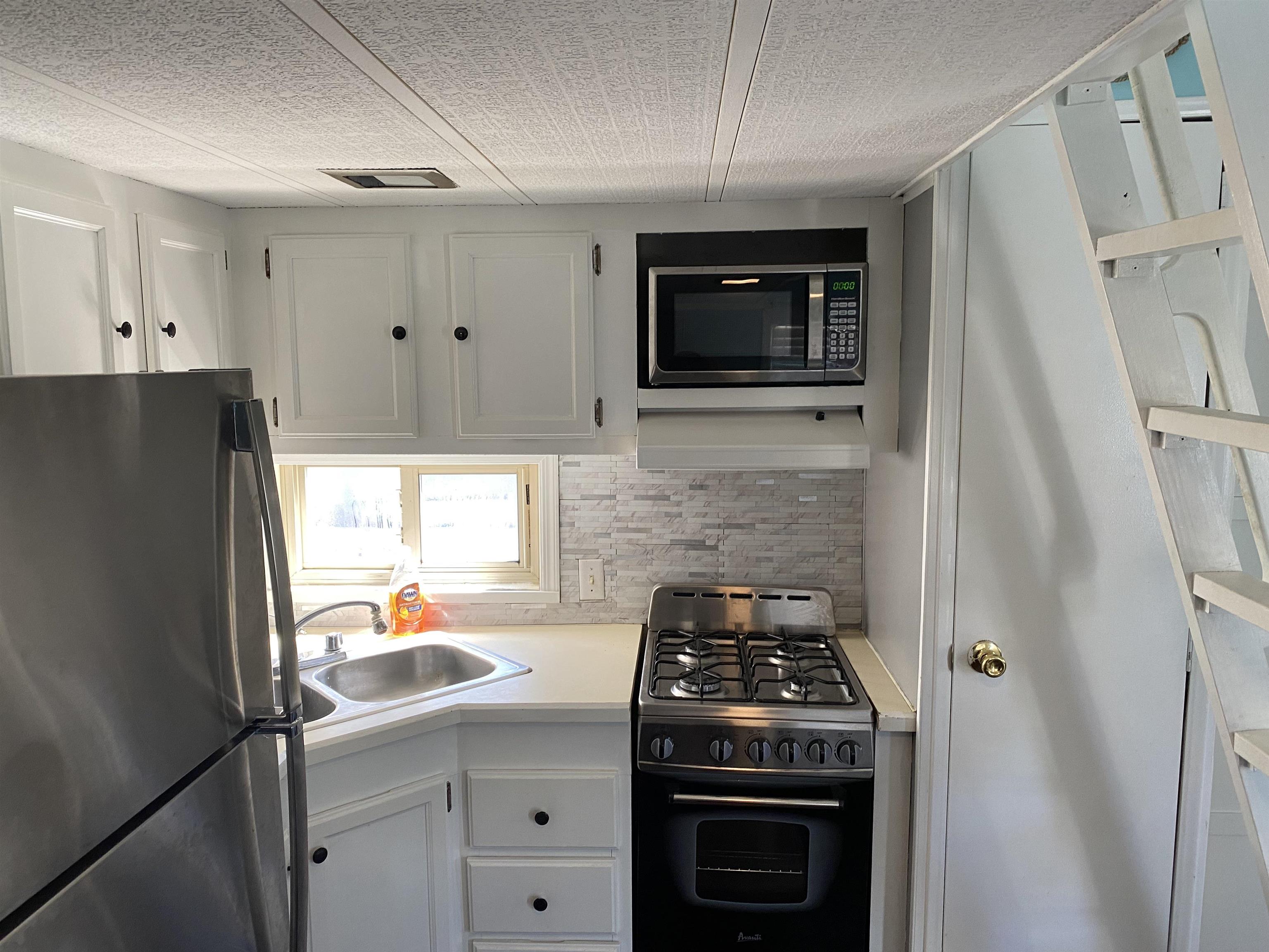 515 Corsons Tavern Road Ocean View, NJ 08230 - Photo 7 of 18 a kitchen with stainless steel appliances a stove a microwave and a refrigerator
