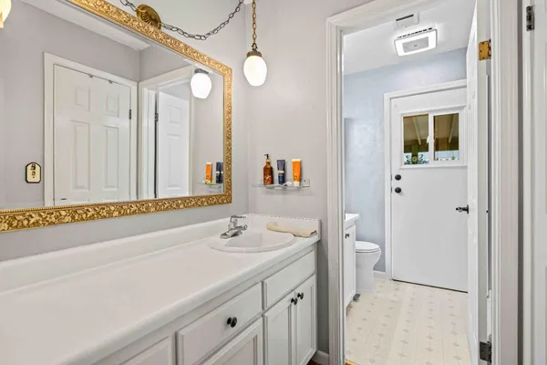 a bathroom with a sink a toilet and a large mirror