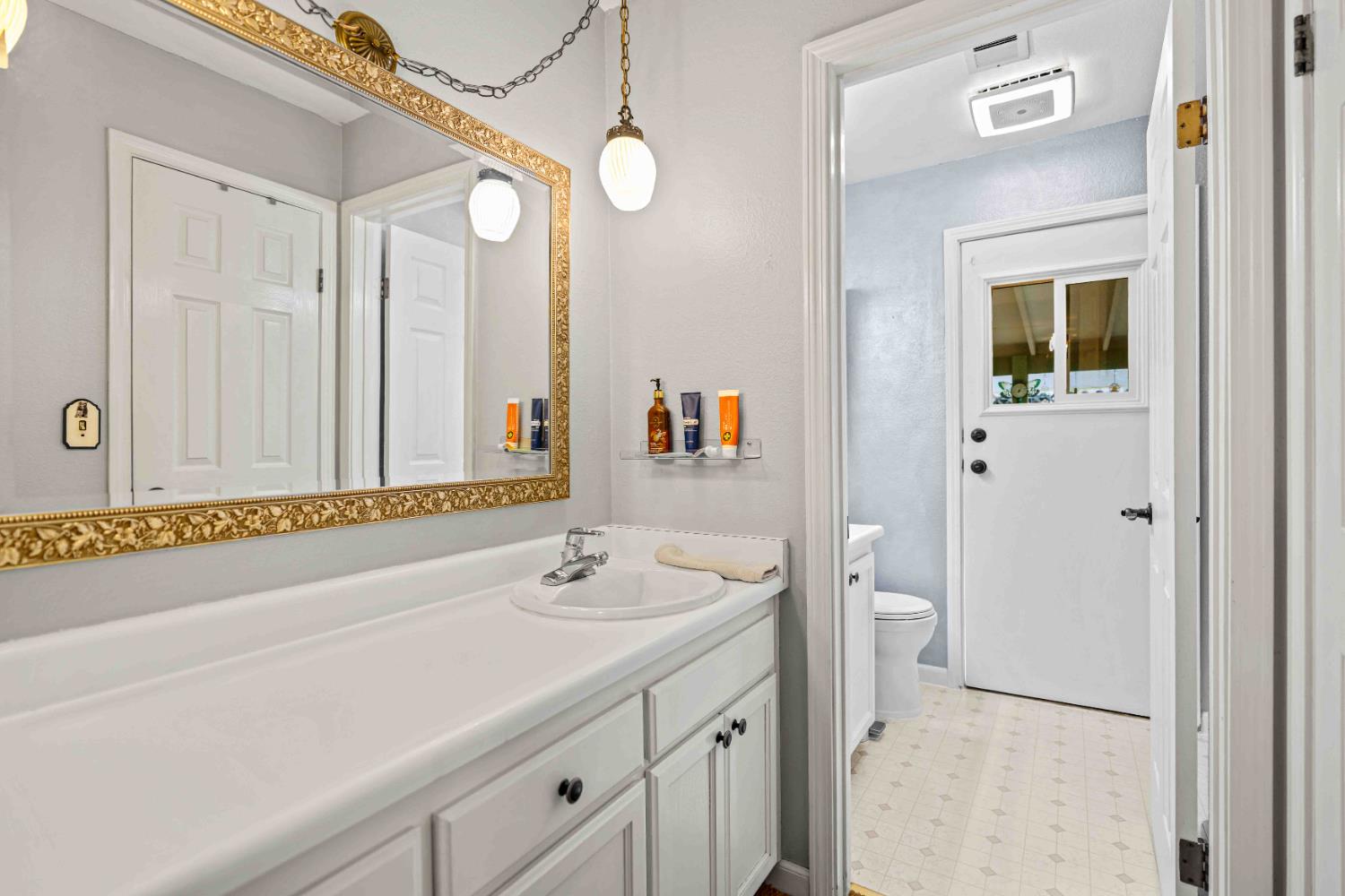 3913 Peacock Lane Modesto, CA 95356 - Photo 11 of 21 a bathroom with a sink a toilet and a large mirror