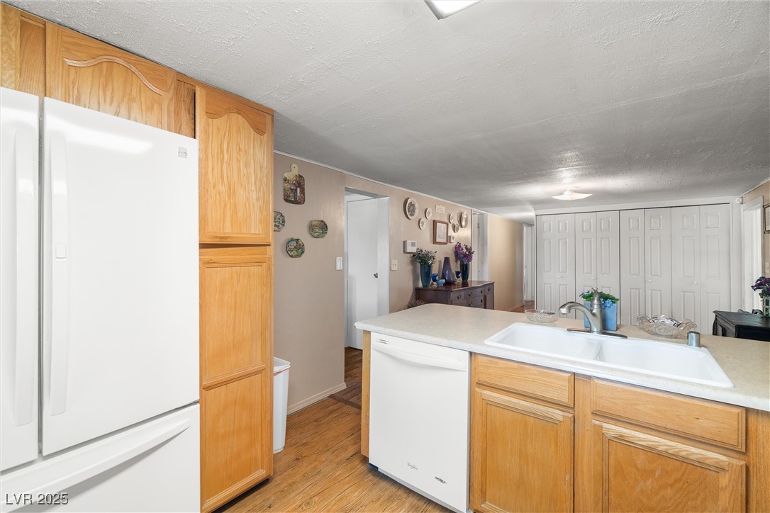 101 West Pechstein Road Pahrump, NV 89060 - Photo 12 of 33 Kitchen featuring light countertops, light wood-type flooring & white appliances.