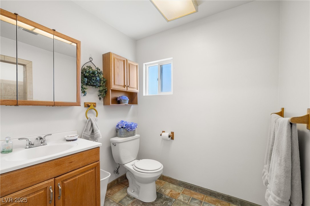 101 West Pechstein Road Pahrump, NV 89060 - Photo 17 of 33 Bathroom with stone finish flooring, newer toilet, and vanity.