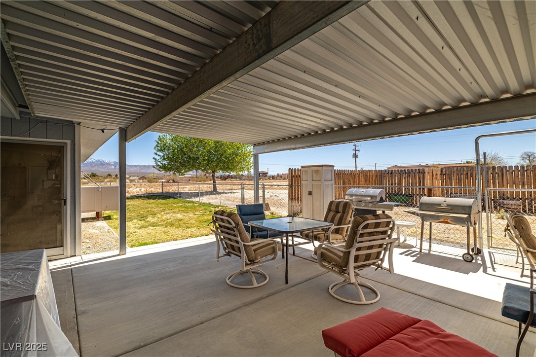 101 West Pechstein Road Pahrump, NV 89060 - Photo 24 of 33 View of patio / terrace featuring area for grilling, fence, and outdoor dining space. Shaded on the side for extra comfort in the summer heat.
