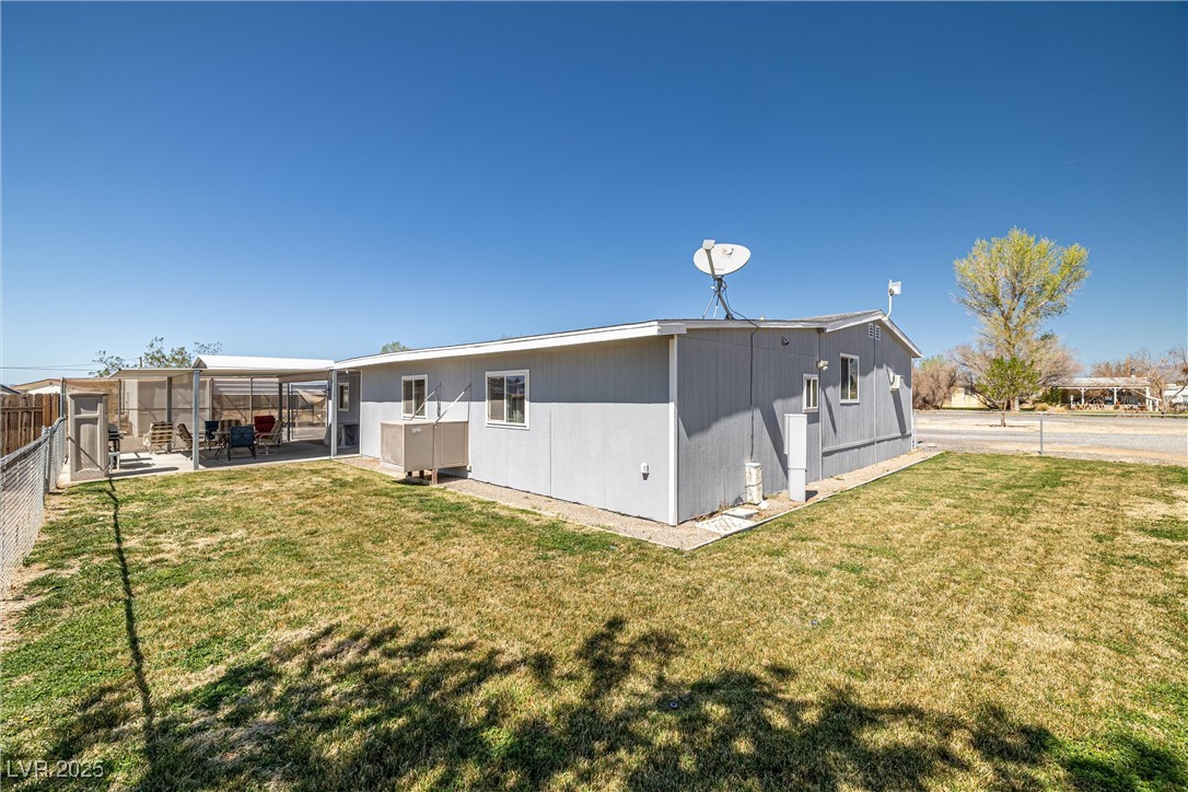 101 West Pechstein Road Pahrump, NV 89060 - Photo 28 of 33 Rear view of house with fence, a yard, and a covered patio area