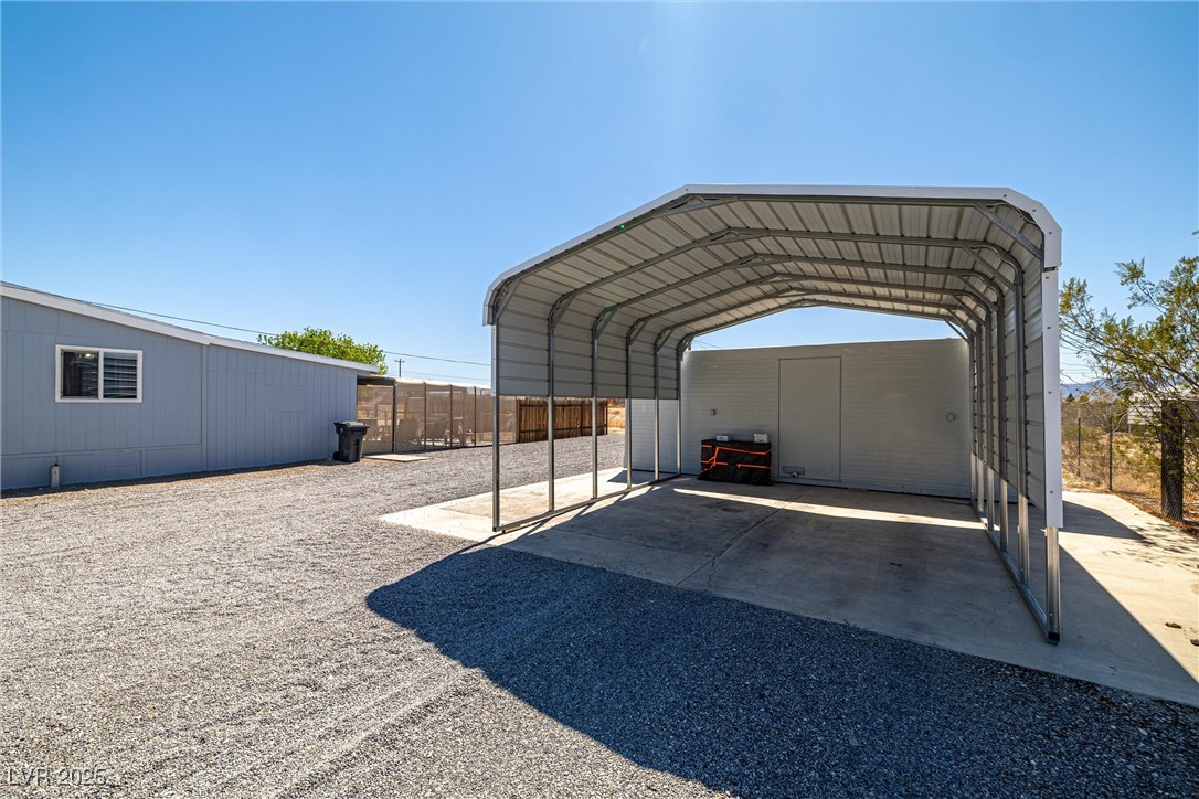 101 West Pechstein Road Pahrump, NV 89060 - Photo 29 of 33 View of car parking with driveway, fence, and a detached 2 car carport.