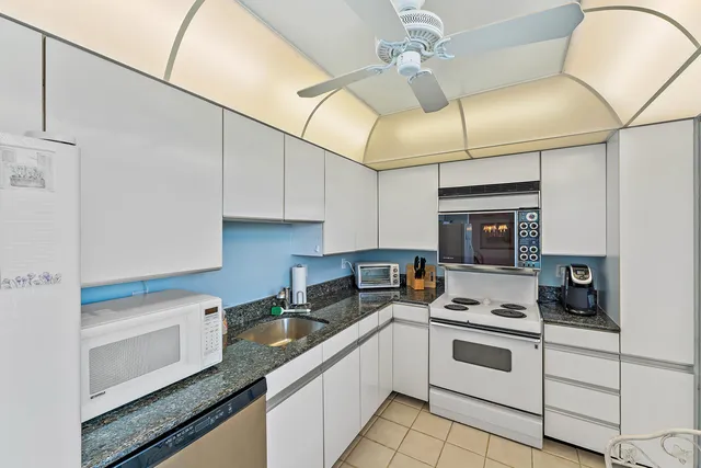 a kitchen with granite countertop cabinets stainless steel appliances and a counter space