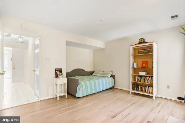 a living room with baby crib furniture and a wooden floor