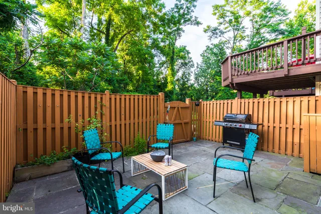 a backyard of a house with a wooden bench and outdoor seating