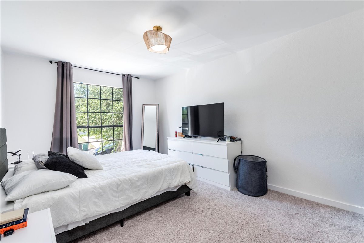 1707 Yucca Lane Cedar Park, TX 78613 - Photo 19 of 26 a bedroom with a bed a flat screen tv and a window