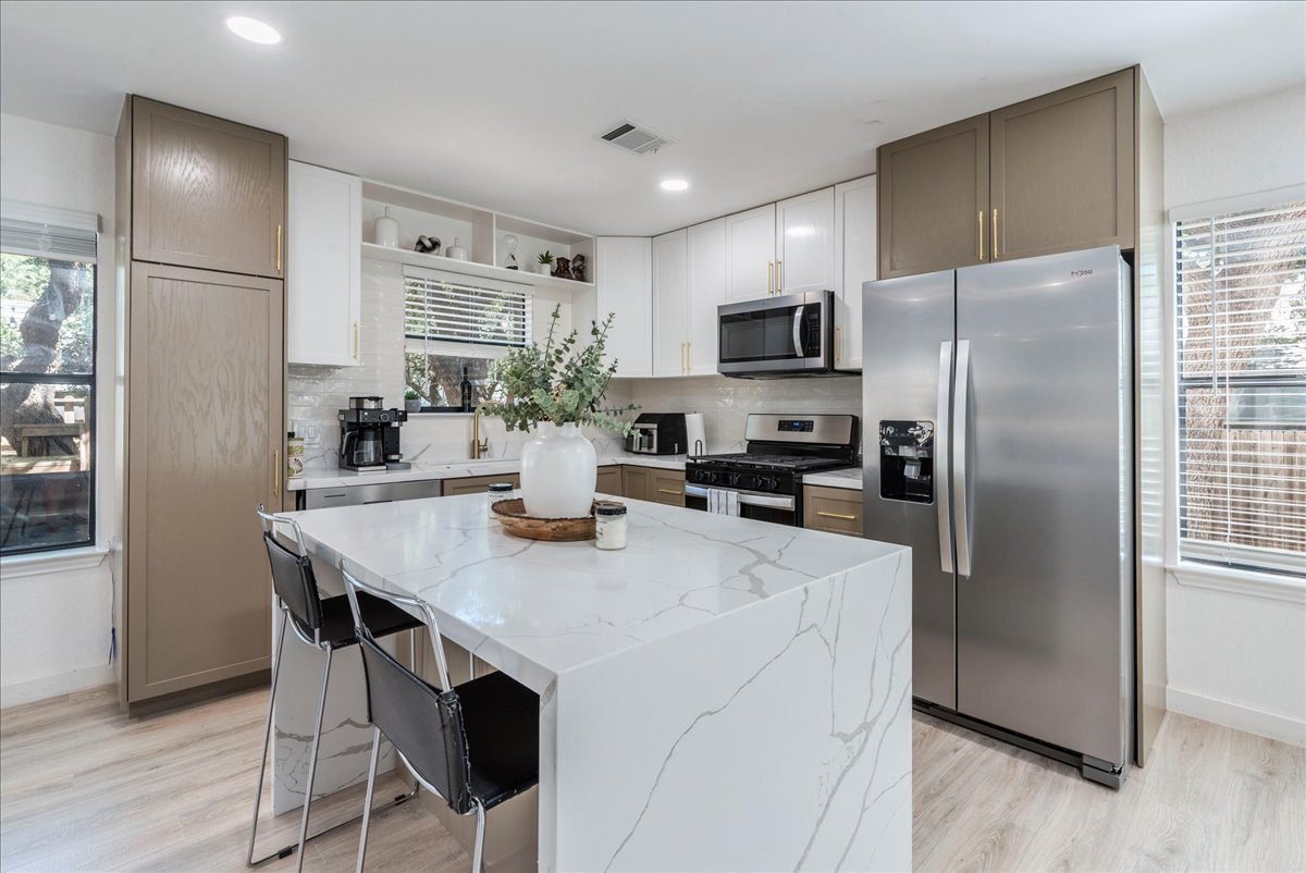 1707 Yucca Lane Cedar Park, TX 78613 - Photo 2 of 26 a kitchen with kitchen island a refrigerator stove microwave and cabinets