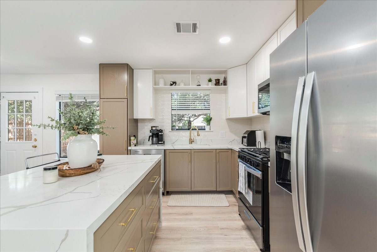 1707 Yucca Lane Cedar Park, TX 78613 - Photo 8 of 26 a kitchen with stainless steel appliances granite countertop a sink stove and refrigerator