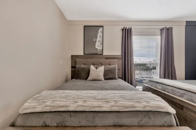 a large bed sitting in a bedroom next to a window