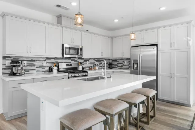 a kitchen with kitchen island granite countertop a sink a center island and stainless steel appliances