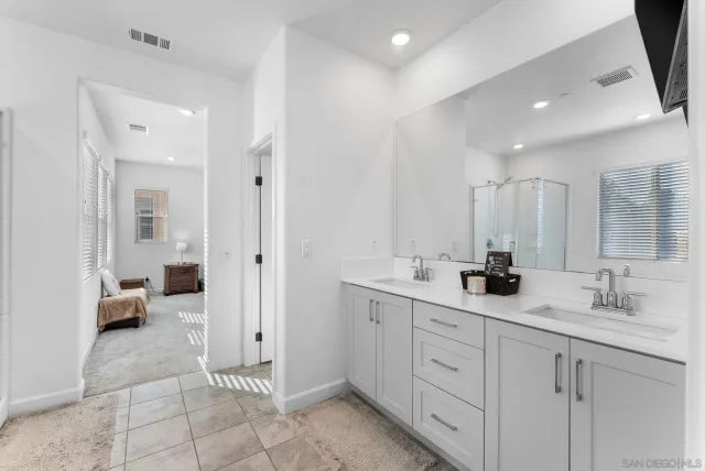 a spacious bathroom with a double vanity sink and mirror