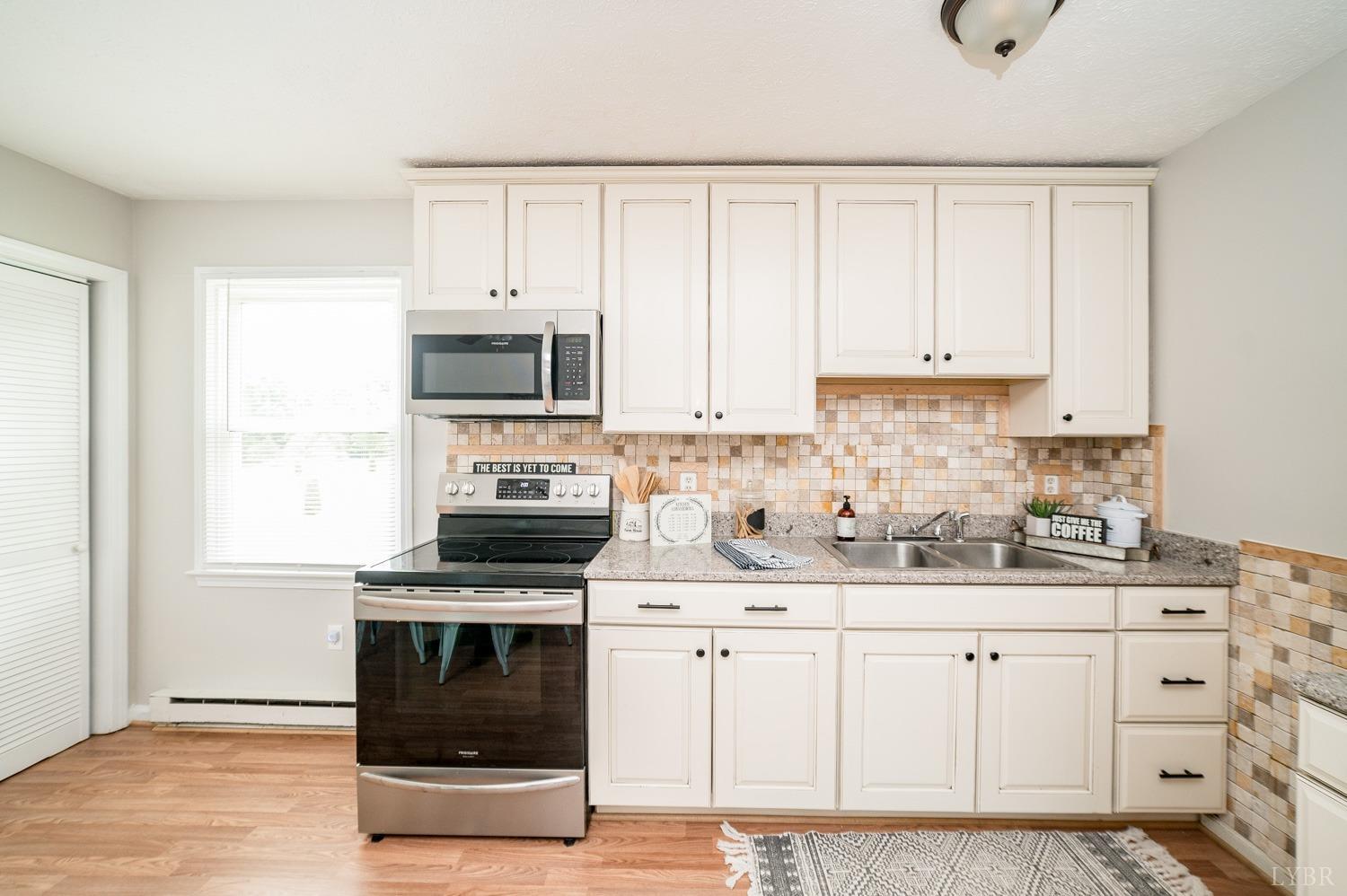 1164 English Tavern Road Rustburg, VA 24588 - Photo 13 of 46 a kitchen with white cabinets and appliances
