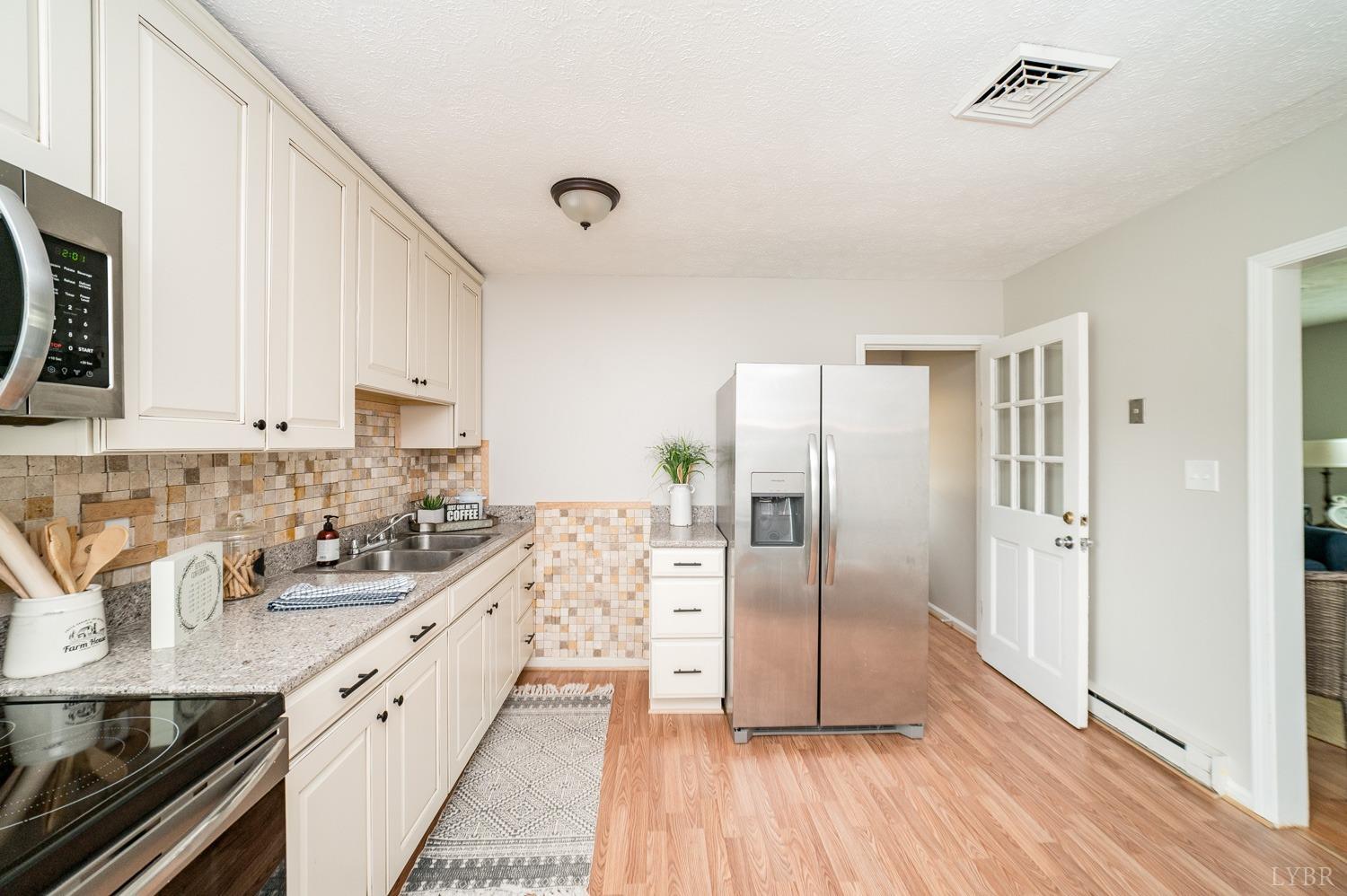 1164 English Tavern Road Rustburg, VA 24588 - Photo 16 of 46 a kitchen with stainless steel appliances a sink a stove a refrigerator and cabinets