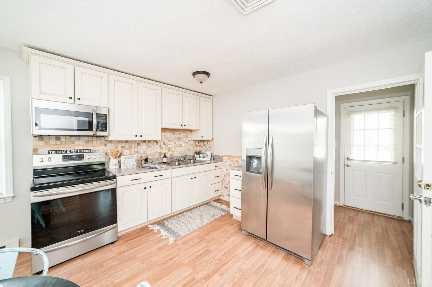 1164 English Tavern Road Rustburg, VA 24588 - Photo 17 of 46 a kitchen with stainless steel appliances cabinets a wooden floor and a sink