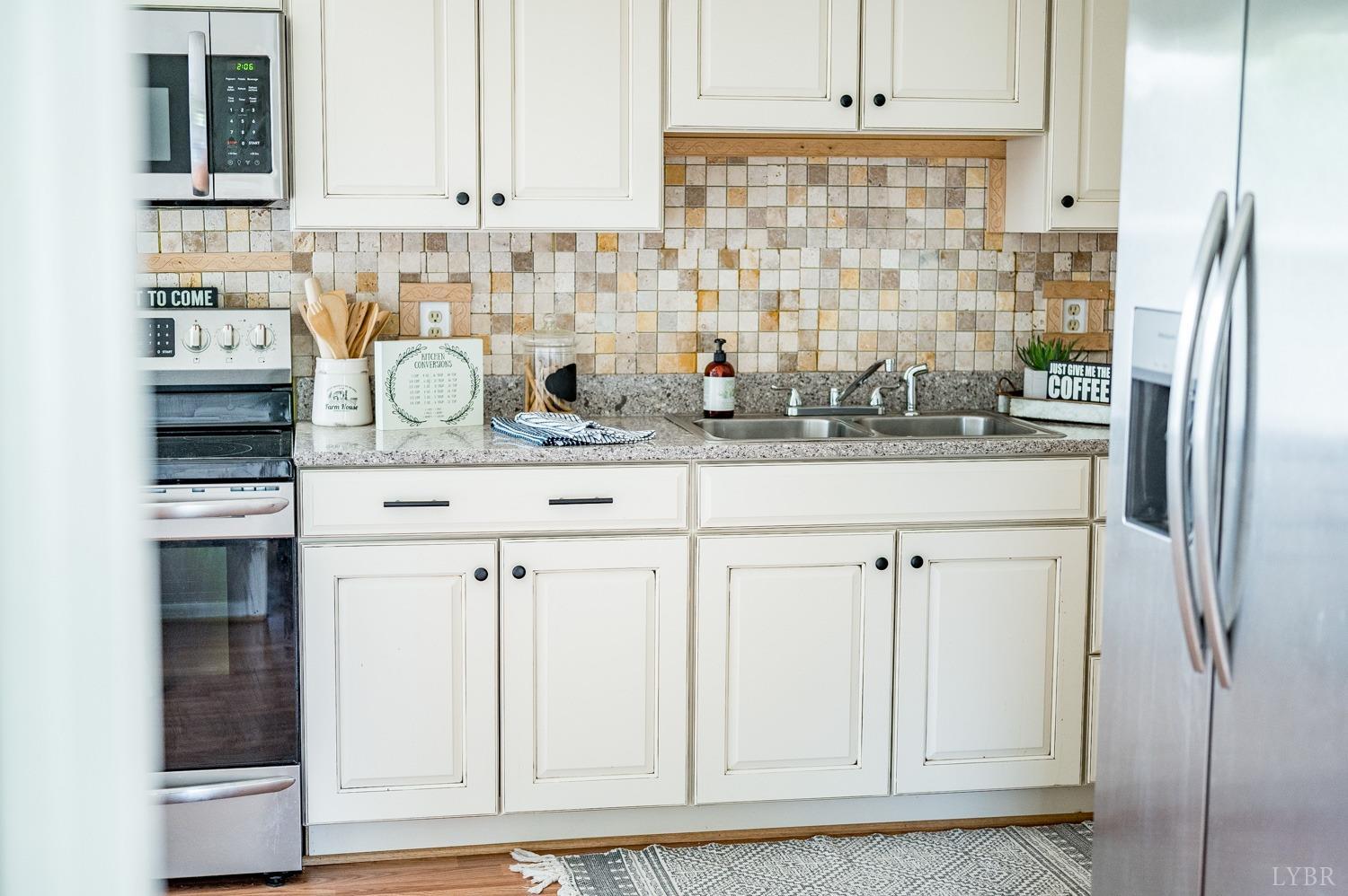 1164 English Tavern Road Rustburg, VA 24588 - Photo 18 of 46 a kitchen with stainless steel appliances white cabinets and a refrigerator