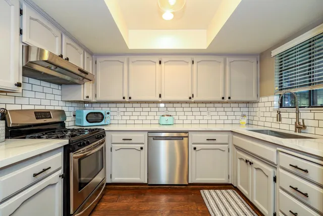a kitchen with stainless steel appliances a stove sink and cabinets