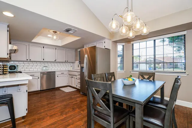 a open dining room with stainless steel appliances a table and chairs in it