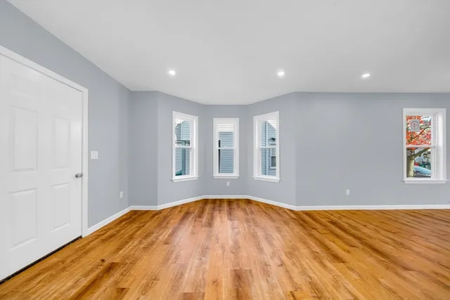 a view of a big room with wooden floor and windows