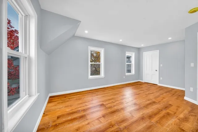 a view of a white house with a large space and a yard