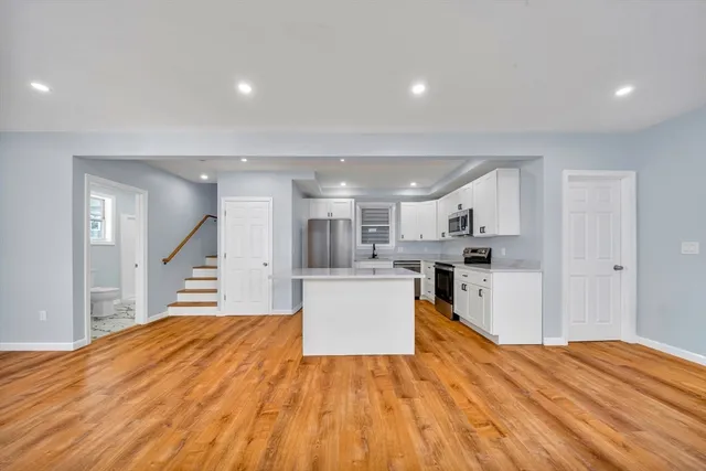 a large kitchen with a wooden floor and a view of kitchen