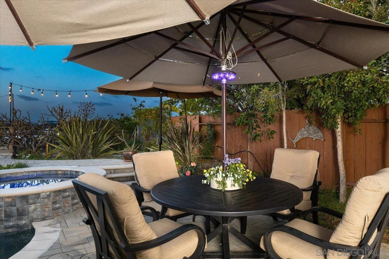 3746 Kelton Drive Oceanside, CA 92056 - Photo 8 of 49 a patio with a table and chairs under an umbrella