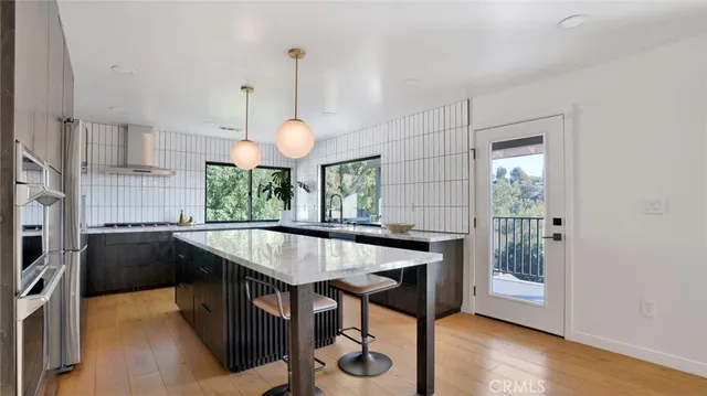 a kitchen with stainless steel appliances granite countertop a sink a stove and a refrigerator