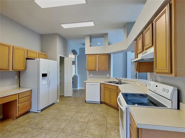 a kitchen with a stove a refrigerator and a sink