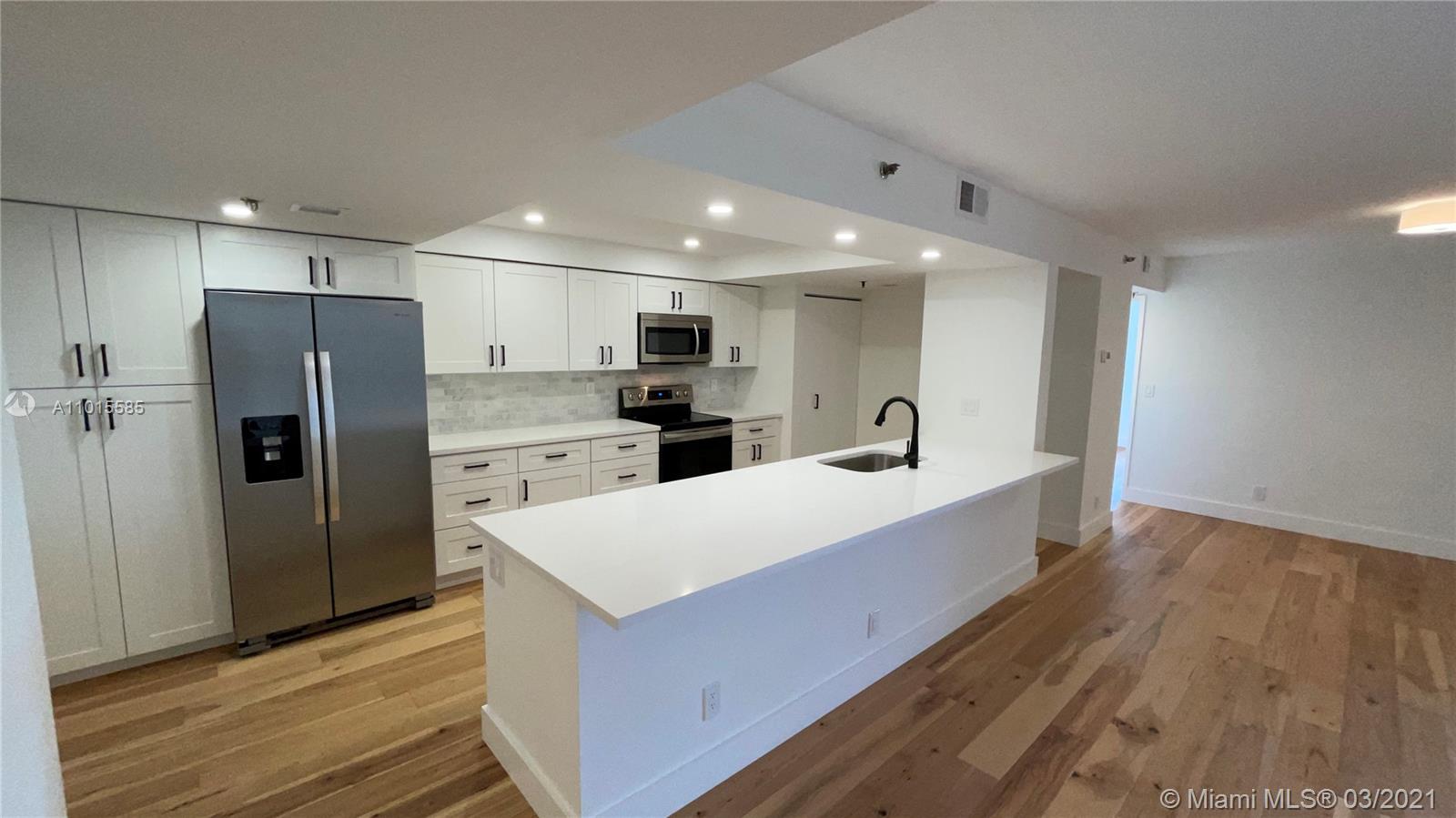 a large kitchen with stainless steel appliances a refrigerator and a stove top oven