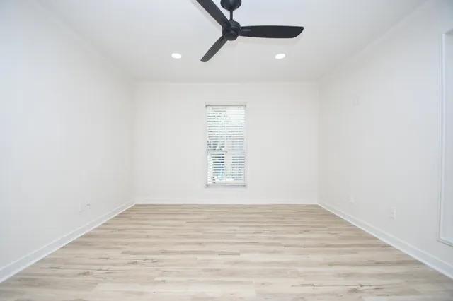 a view of empty room with wooden floor