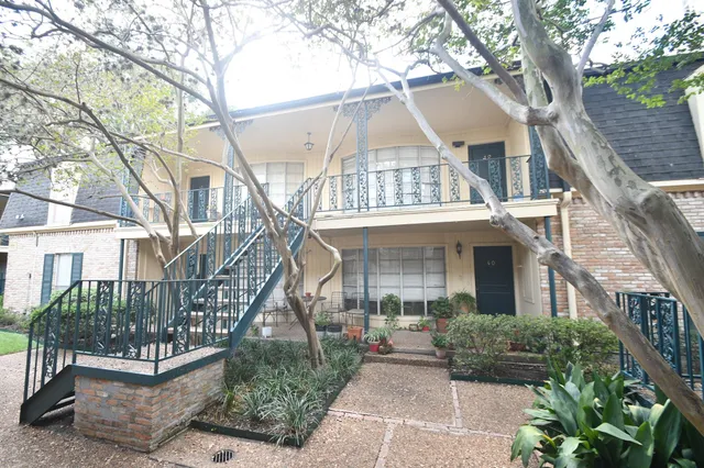 a front view of a house with garden and plants