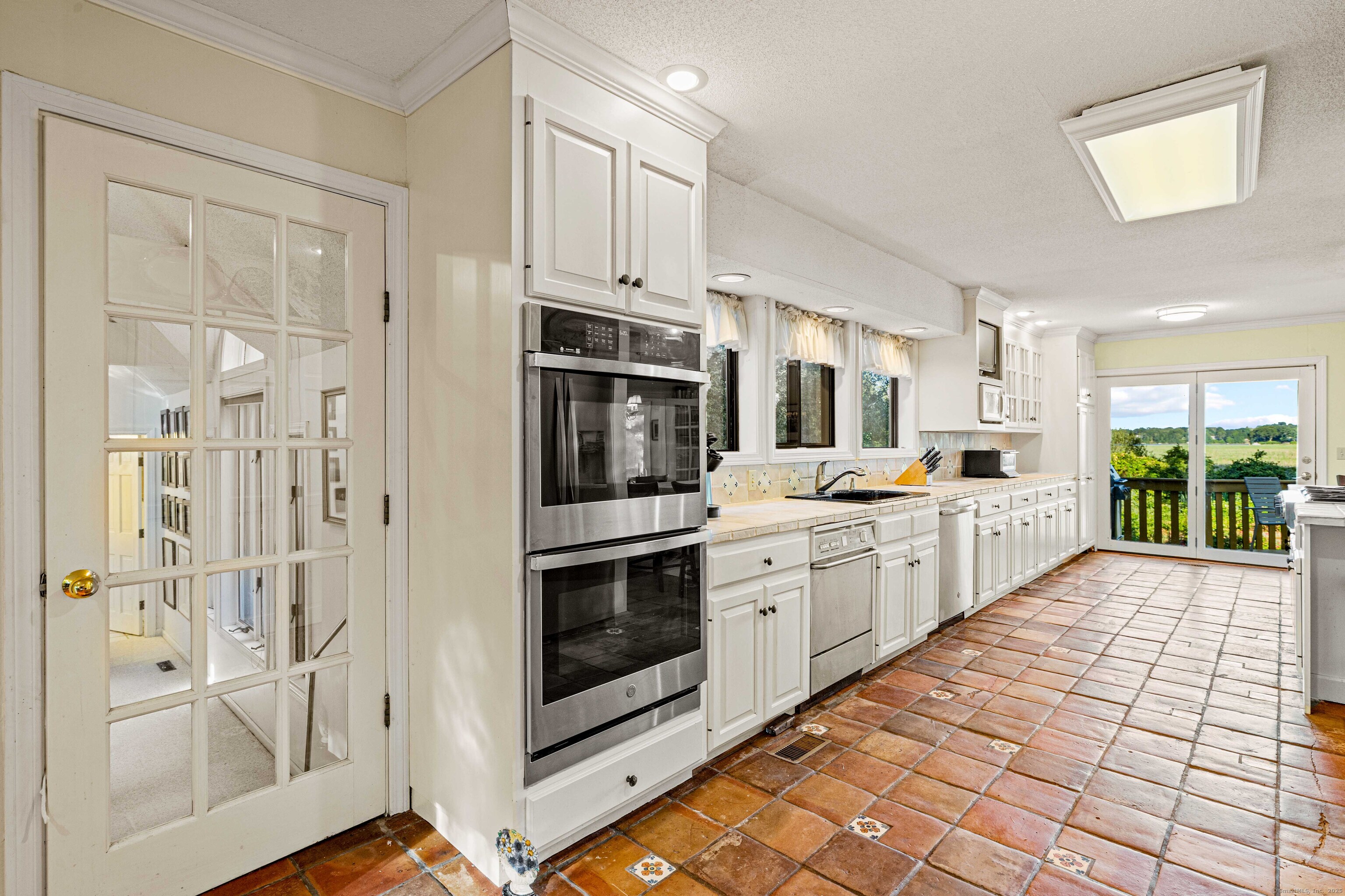 96 Ayers Point Road Old Saybrook, CT 06475 - Photo 9 of 39 a large white kitchen with cabinets and stainless steel appliances
