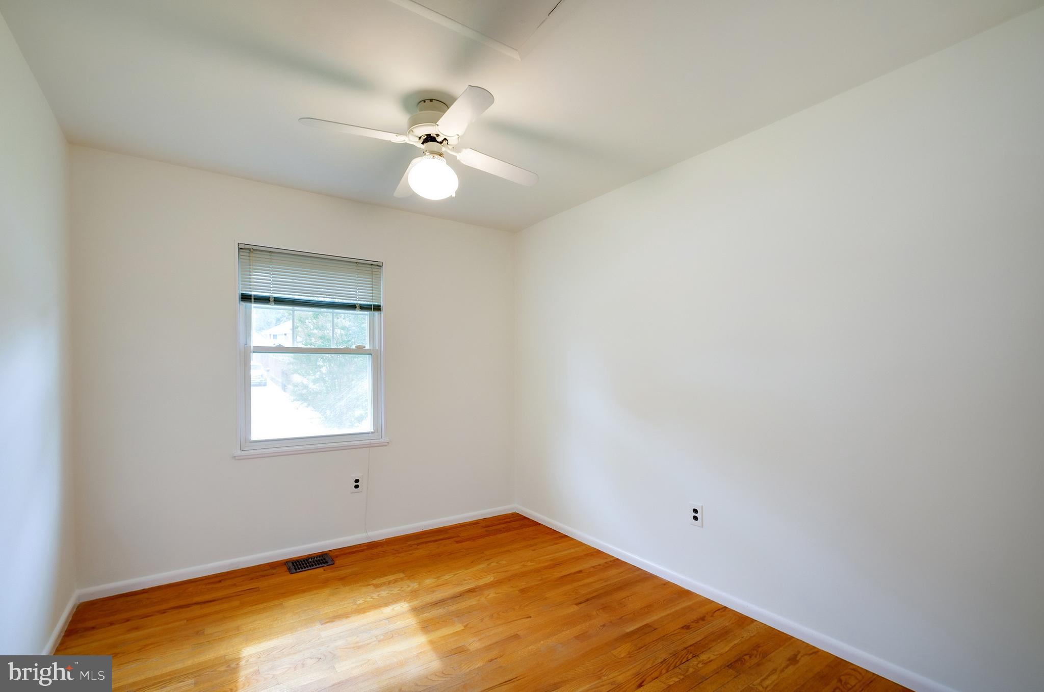 9212 Morley Road Lanham, MD 20706 - Photo 27 of 64 an empty room with a chandelier fan and windows