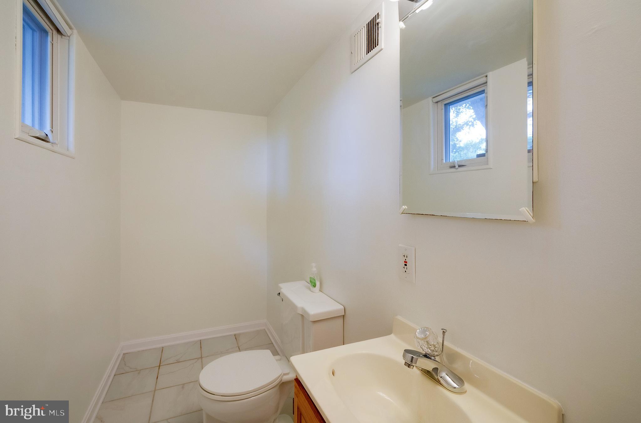 9212 Morley Road Lanham, MD 20706 - Photo 43 of 64 a bathroom with a toilet a sink and mirror