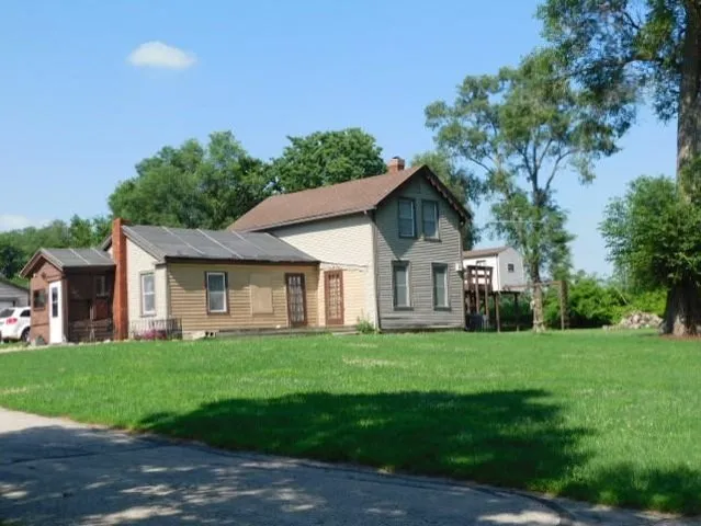 a front view of a house with a yard and trees