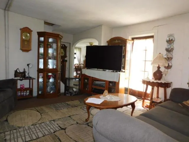 a living room with furniture a rug and a flat screen tv