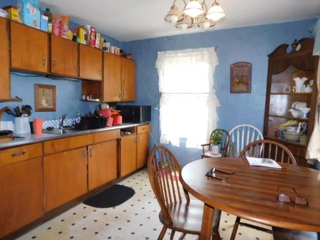 a kitchen with a table chairs a stove a dining table and chairs