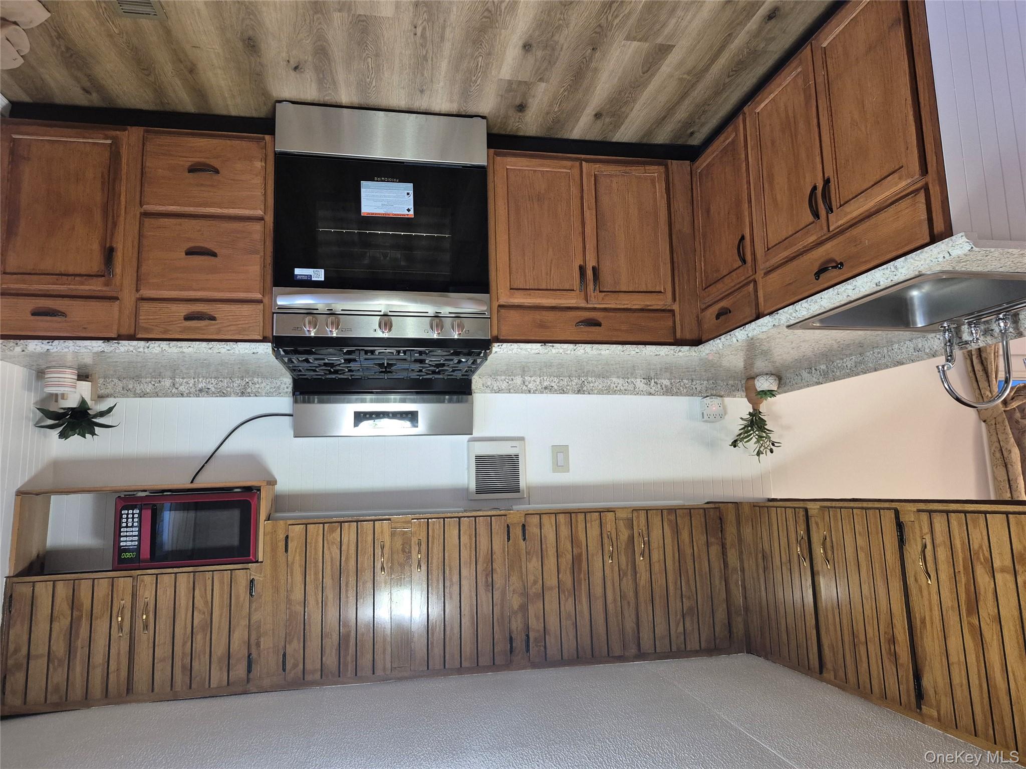 363 Mettacahonts Road, Unit 5 Accord, NY 12404 - Photo 16 of 39 a kitchen with stainless steel appliances granite countertop wooden cabinets a stove top oven a sink and dishwasher
