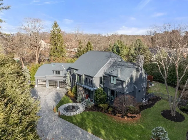 a front view of a house with a yard and large trees