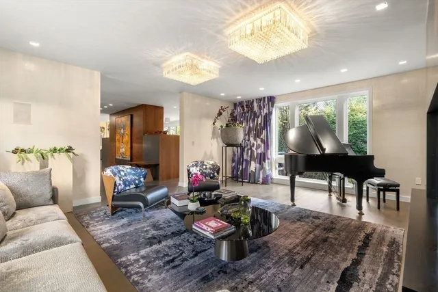 a living room with furniture a chandelier and a large window