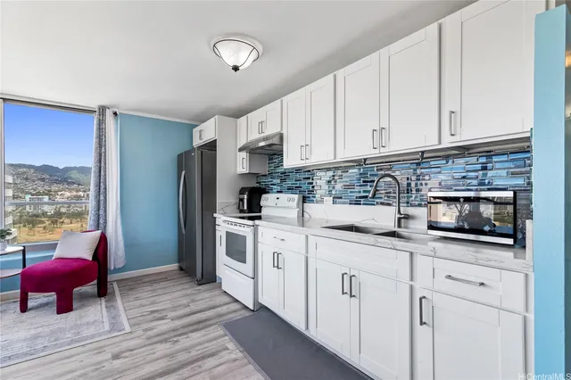 a kitchen with white cabinets and sink