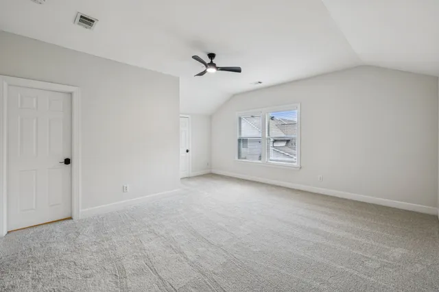 a view of an empty room with fireplace and a window