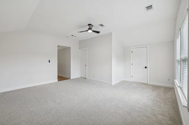 a view of an empty room with a fireplace and a window