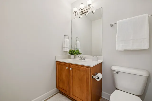 front view of a brick house with a yard and potted plants