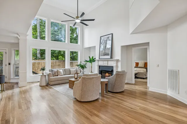 a living room with furniture a large window and a fireplace