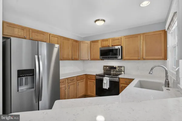 a kitchen with stainless steel appliances granite countertop a refrigerator stove top oven a sink and dishwasher