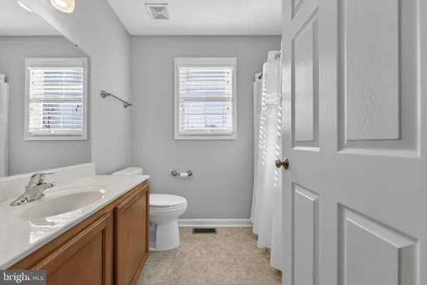 a bathroom with a sink toilet and window